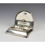 An Edwardian silver desk stand, with arched calendar top, pen rest and inkwell (glass missing), four