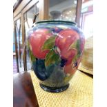 A signed Moorcroft pomegranate patterned vase.Chip to underside of foot and hairline cracks.