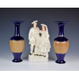 A Staffordshire figure group, depicting a couple of market sellers, 14in. (35.5cm.)high, together