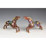 A pair of Chinese cloisonn‚? horses, mid-century, in mid gallop, deep red ground, decorated with