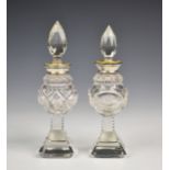 A near pair of Edwardian cut glass, silver & enamel perfume bottles, the silver and yellow guilloche