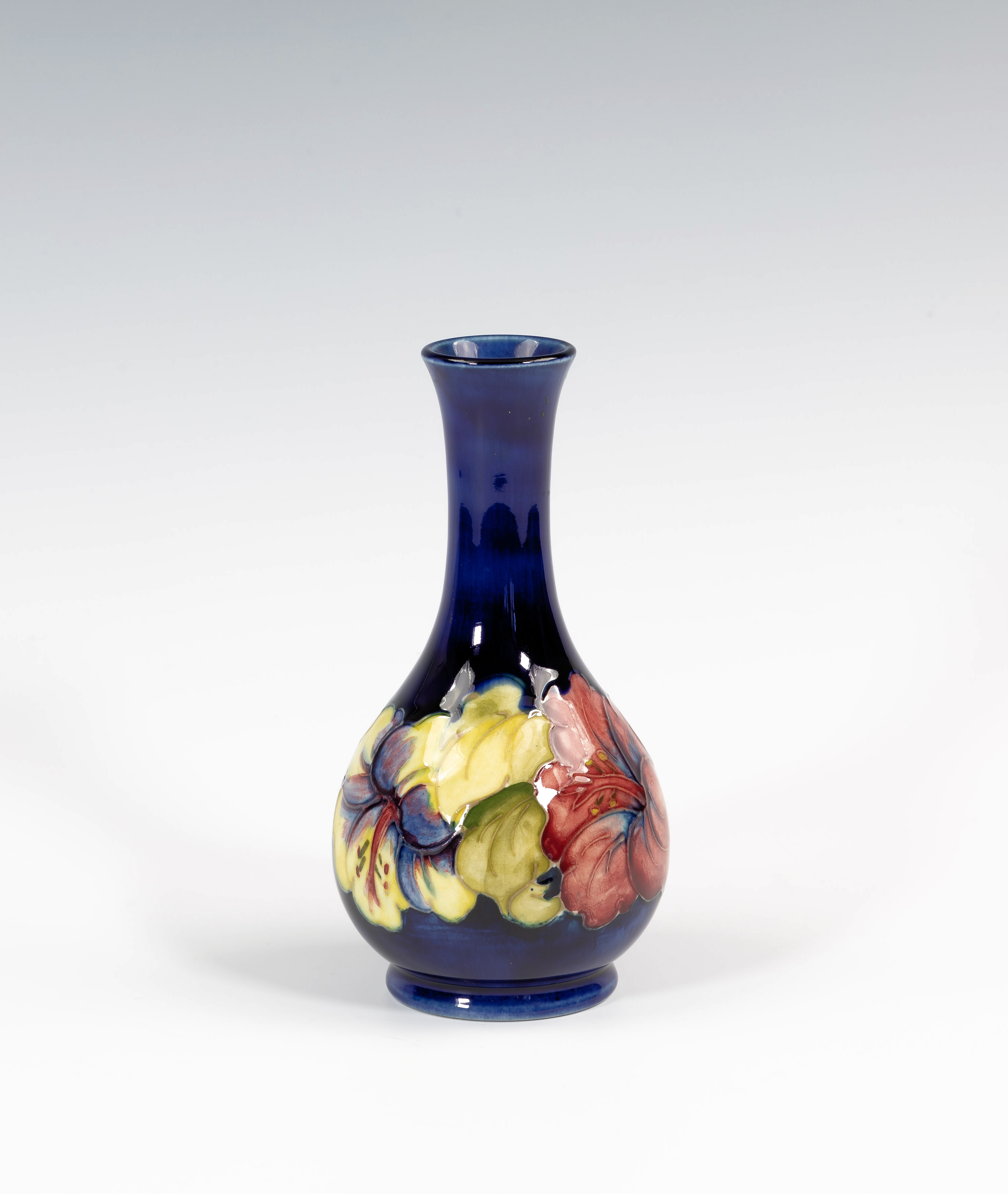 A Moorcroft Hibiscus pattern bottle vase, 1950s-60s, with Royal blue ground, paper label to base (