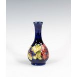 A Moorcroft Hibiscus pattern bottle vase, 1950s-60s, with Royal blue ground, paper label to base (