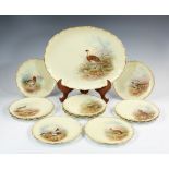 A set of twelve Royal Doulton Burslem cabinet plates and platter hand painted with game birds,