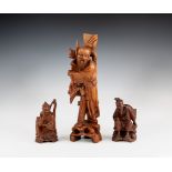 Three 20th century Chinese carved wooden figures of travellers, the tallest (possibly a lamp