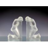 A pair of Lalique Reverie clear and frosted glass bookends, depicting kneeling young female nudes,