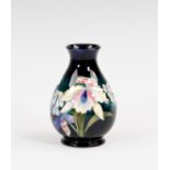 A Moorcroft orchid pattern vase, 1930s-40s, ovoid form, painted with purple and white orchids on a