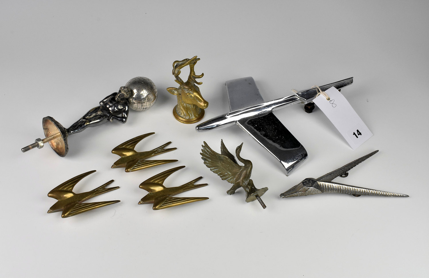 An assortment of car mascots & hood ornaments comprising of three brass swift/swallow hood