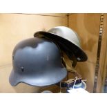 A British military helmet and a replica German WW2 helmet.