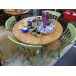 A circular painted pine table with four chairs.,