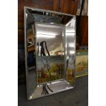 A large bevelled glass wall mirror.