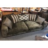 A very large contemporary dark grey chenille sofa with scatter cushions and matching footstool.