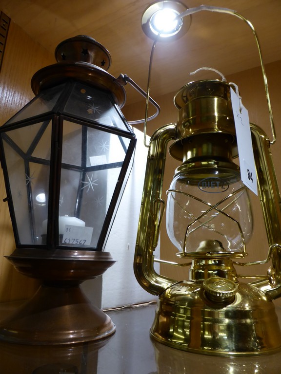 A brass Nauticalia Hurricane oil lamp and a candle holder.