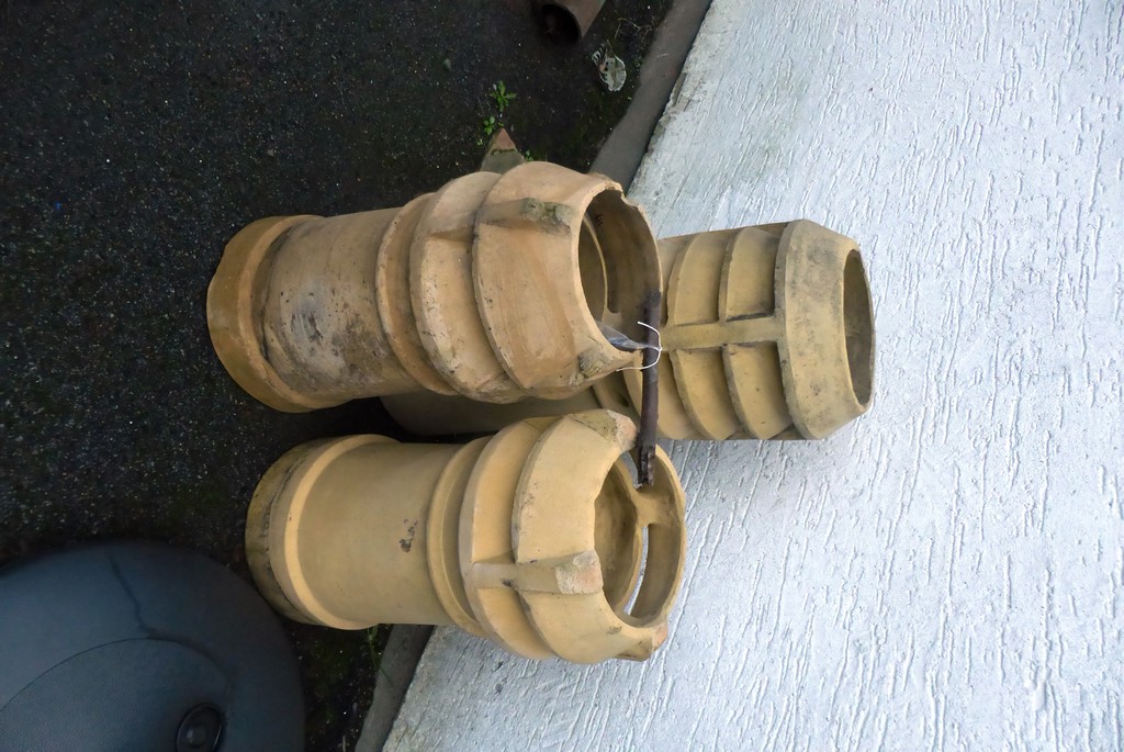 Three reclaimed buff louvred chimney pots.