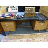 A vintage mid-century teak desk with black vinyl top by Lucas,72in, (183cm.) long.