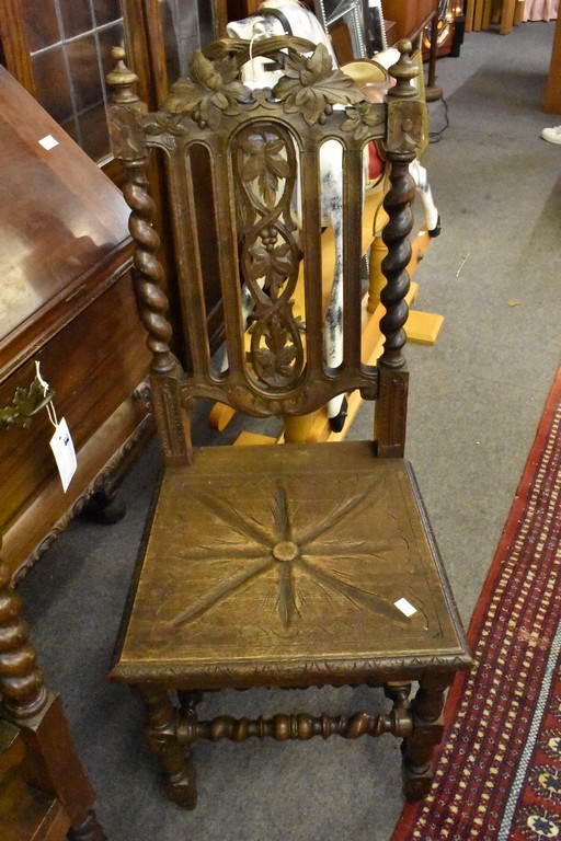 A pair of late Victorian carved oak hall chairs.