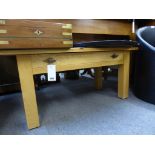 A light oak rectangular coffee table with single drawer.