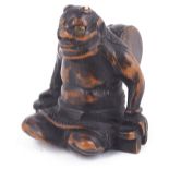 ˜DARK STAINED WOOD NETSUKE OF THE THUNDER GOD RAIDEN, CIRCA 1850 seated making thunder with his wood