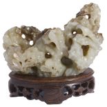 A CHINESE GREY JADE ROCKWORK BRUSH REST carved and pierced as rockwork with a reclining figure and a