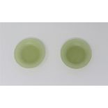 A PAIR OF CHINESE CELADON JADE MINIATURE SAUCERS each with gently curved sides rising from a short