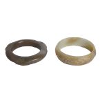 TWO CHINESE ARCHAISTIC JADE BI RINGS one carved in low relief with chilong, the stone of pale