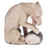 ˜STAINED IVORY NETSUKE OF A WOLF WITH SEVERED HUMAN HEAD, CIRCA 1870 signed: Tomomitsu 4.7cm high