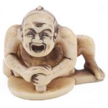 ˜IVORY NETSUKE OF A MIRROR POLISHER, CIRCA 1850 signed: Masayuki 3.2cm high Provenance: The