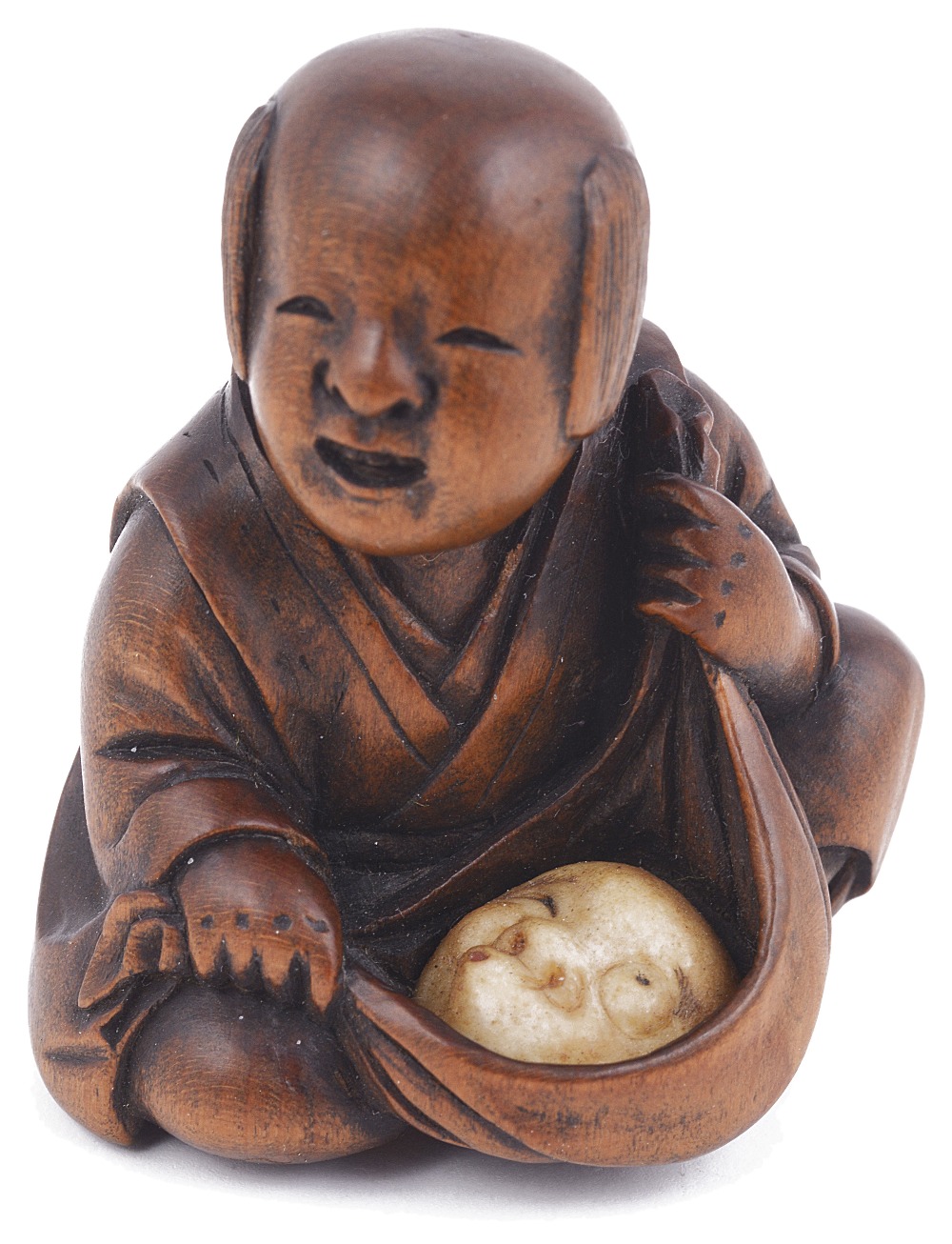 WOOD NETSUKE OF A BOY WITH A MASK IN A FUROSHIKI, CIRCA 1870 the mask of Hyottoko carved from ivory,