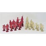 ˜A CHINESE CARVED IVORY CHESS SET, PROBABLY CANTON, CIRCA 1900 natural or red stained, carved as a