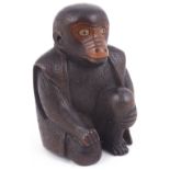 WOOD NETSUKE OF A SEATED PERFORMING MONKEY, CIRCA 1870 wearing a jacket, and with inlaid horn
