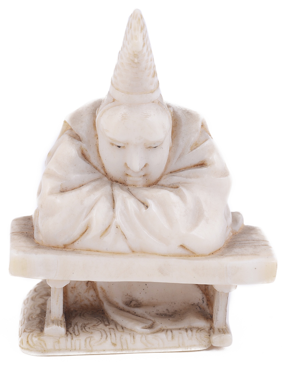 ˜IVORY NETSUKE OF A COURTIER LEANING ON A TABLE, CIRCA 1870 signed: Hirotada 3.7cm high