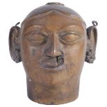 A BRONZE GAURI HEAD, NORTHERN INDIA, 19TH CENTURY her large ears with floral earrings and wire rings