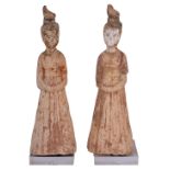 A PAIR OF CHINESE POTTERY FIGURES OF FEMALE ATTENDANTS, TANG DYNASTY (618-907) each standing in long