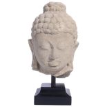 A BUFF SANDSTONE HEAD OF BUDDHA OR A JINA, POST-GUPTA, CENTRAL INDIA, CIRCA 8TH CENTURY from a