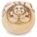 ˜LIGHTLY STAINED IVORY NETSUKE OF THE LUCKY GOD HOTEI IN HIS SACK, CIRCA 1870 looking upwards with a