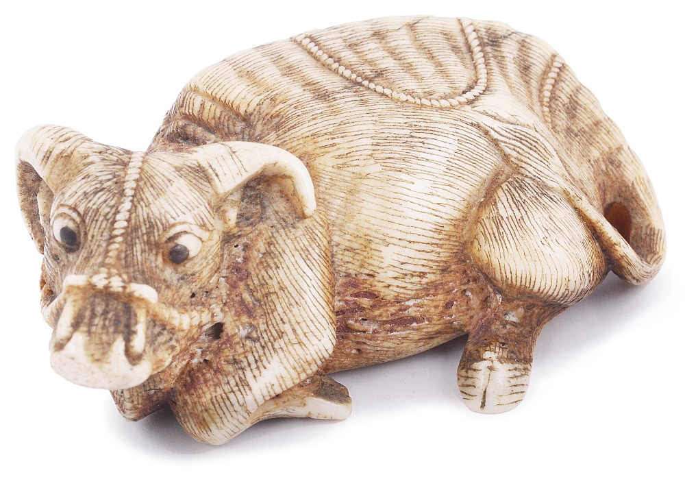 STAG ANTLER NETSUKE OF A RECUMBENT OX, CIRCA 1800 with eyes inlaid in dark horn, signed: Tomomasa