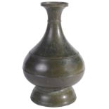 A KHMER BRONZE BOTTLE, CAMBODIA, CIRCA 12TH CENTURY of bulbous form, on flared ring foot, with ridge