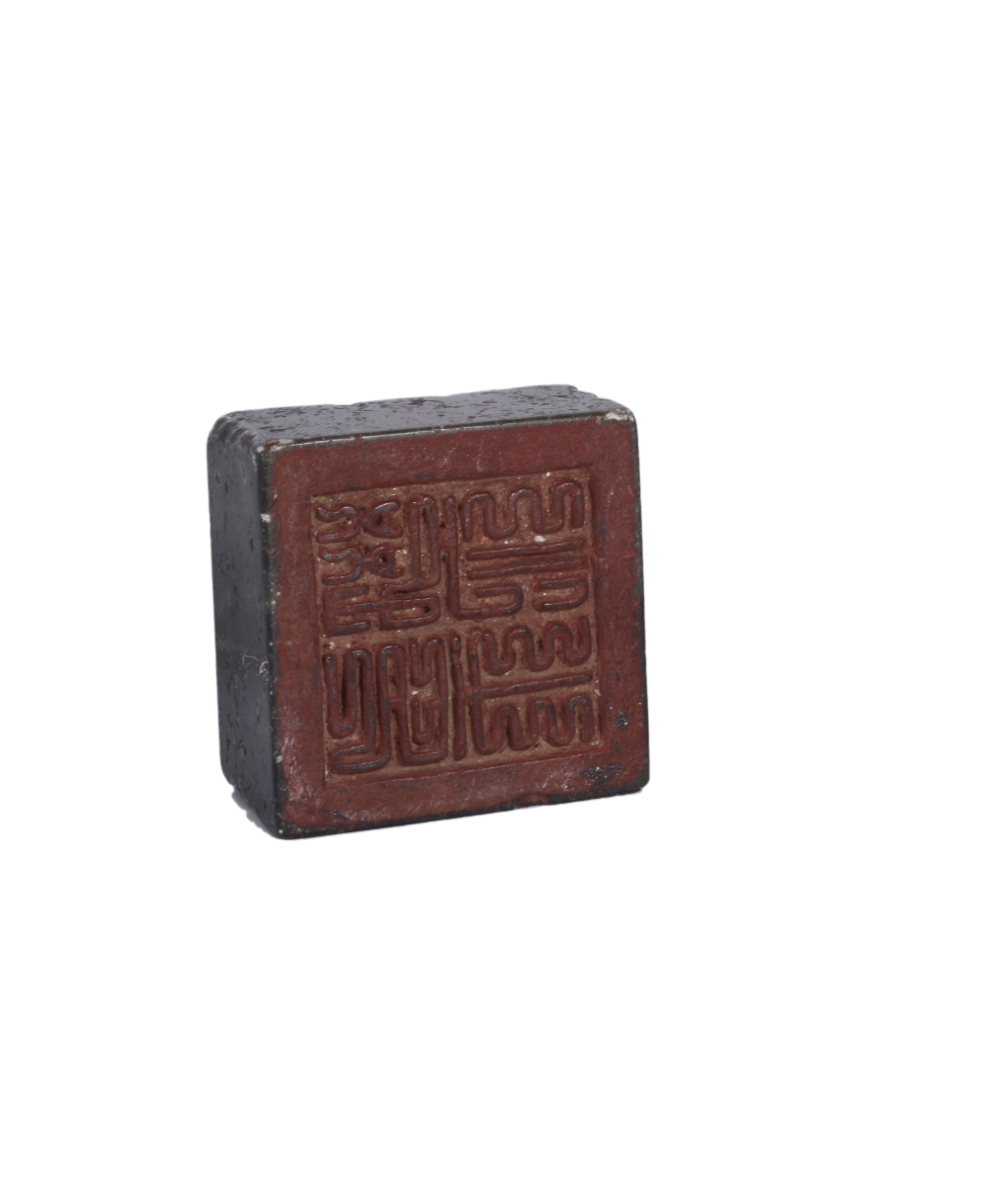 A CHINESE GREEN-GLAZED STONEWARE SEAL of square tapering form, the face carved with four characters,