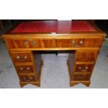 A reproduction yew wood kneehole desk