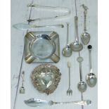 A silver ashtray; a pair of silver sugar tongs; other pieces of silver cutlery; 2 white metal items