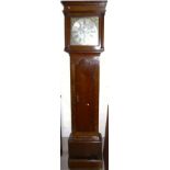 An 18th century oak long case clock, the hood with turned side pillars, arched full length door to