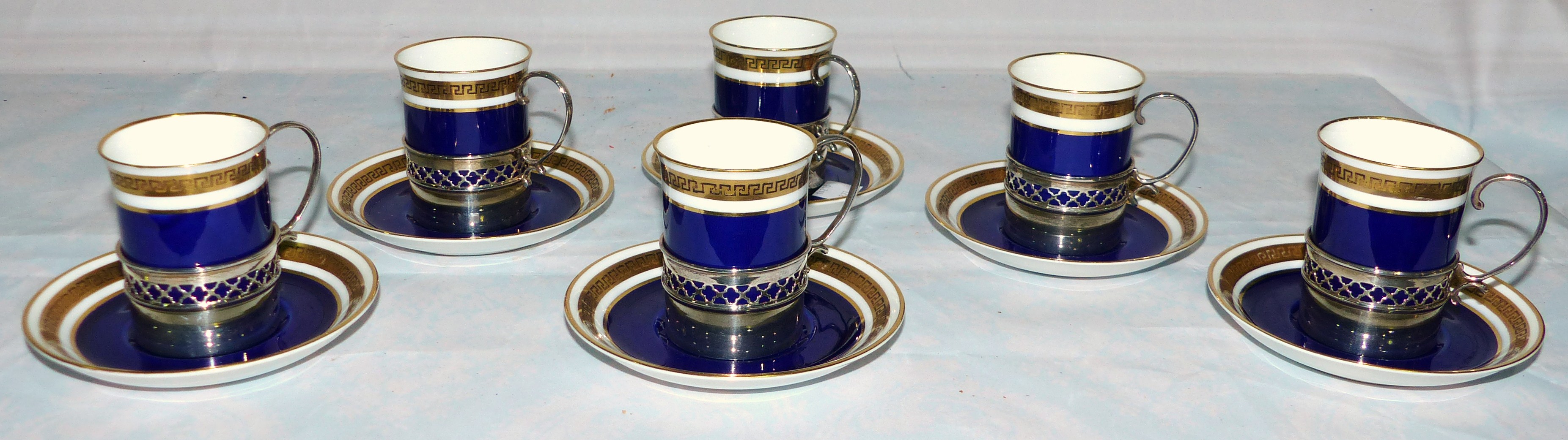 A set of 6 Crescent blue and gilt coffee cups and saucers with hall marked silver mounts