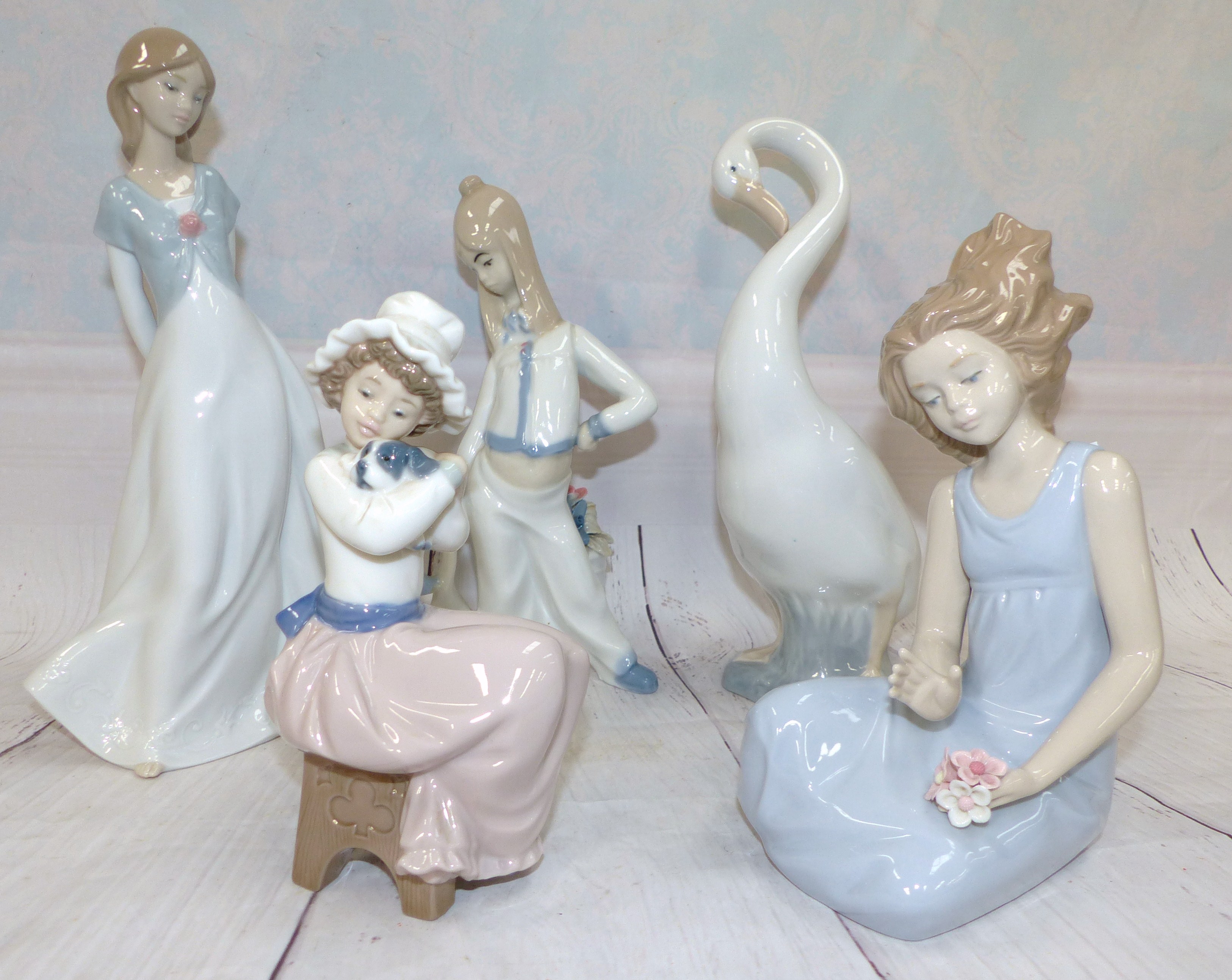 A Nao figure of a Swan, a Nao seated girl, another Nao figure, two similar Spanish figures