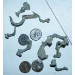 A collection of Roman bronze brooch clasps, four similar period coins