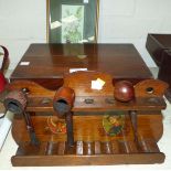A mahogany box, a wooden pipe rack decorated with hunting scenes and pipes, a framed butterfly silk
