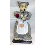 A bear dressed as a seamstress with a porcelain head
