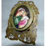 A Victorian cut and engraved brass photograph frame reliquary with inset porcelain plaque of the