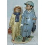 A Lladro group - Boy with Umbrella and Girl with Case height 111/2''