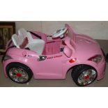 A child's pink electrical car with charger