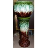 A Victorian majolica jardinière on stand, moulded decoration of mythical beasts, height 36"